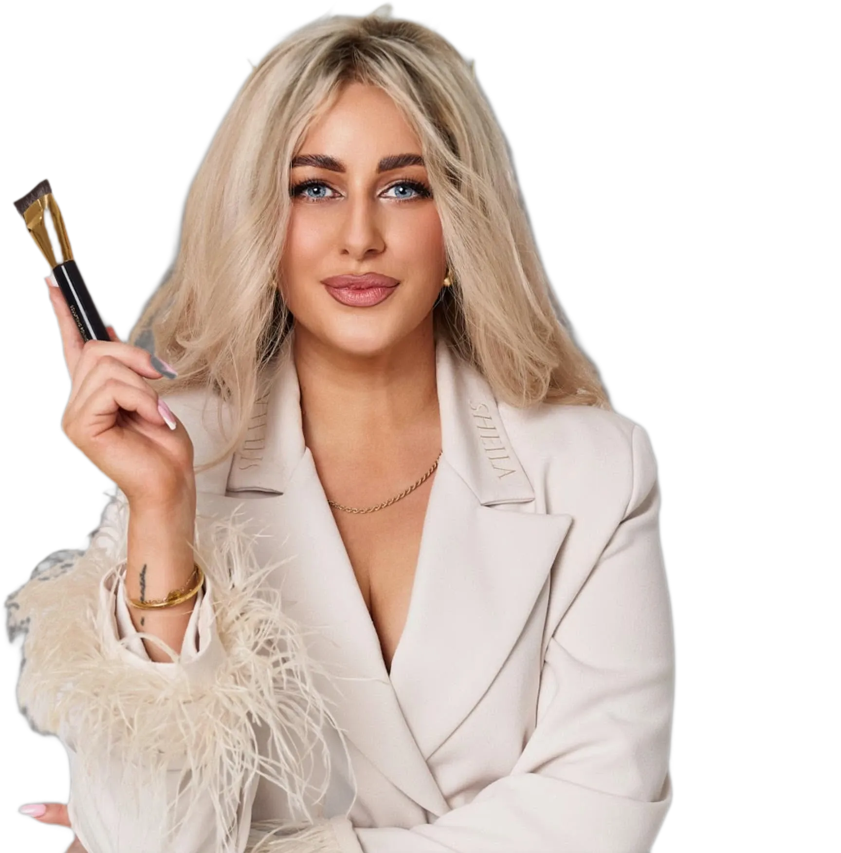 Agata, founder of Agatemia Beauty, holding a gold makeup brush